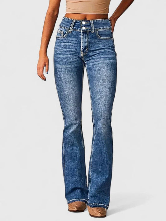 Kvinde iført flared jeans med høj talje og dobbelt knaplukning i mellemblå vask, stylet med nude crop top og brune støvletter._0