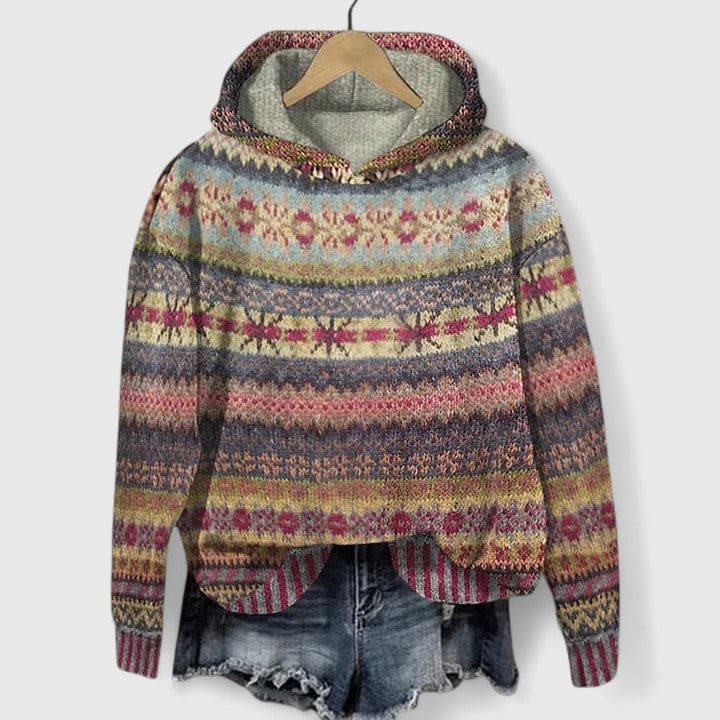 Farverig hættetrøje med striber og etnisk inspireret mønster vist på bøjle med denim shorts i baggrunden_0