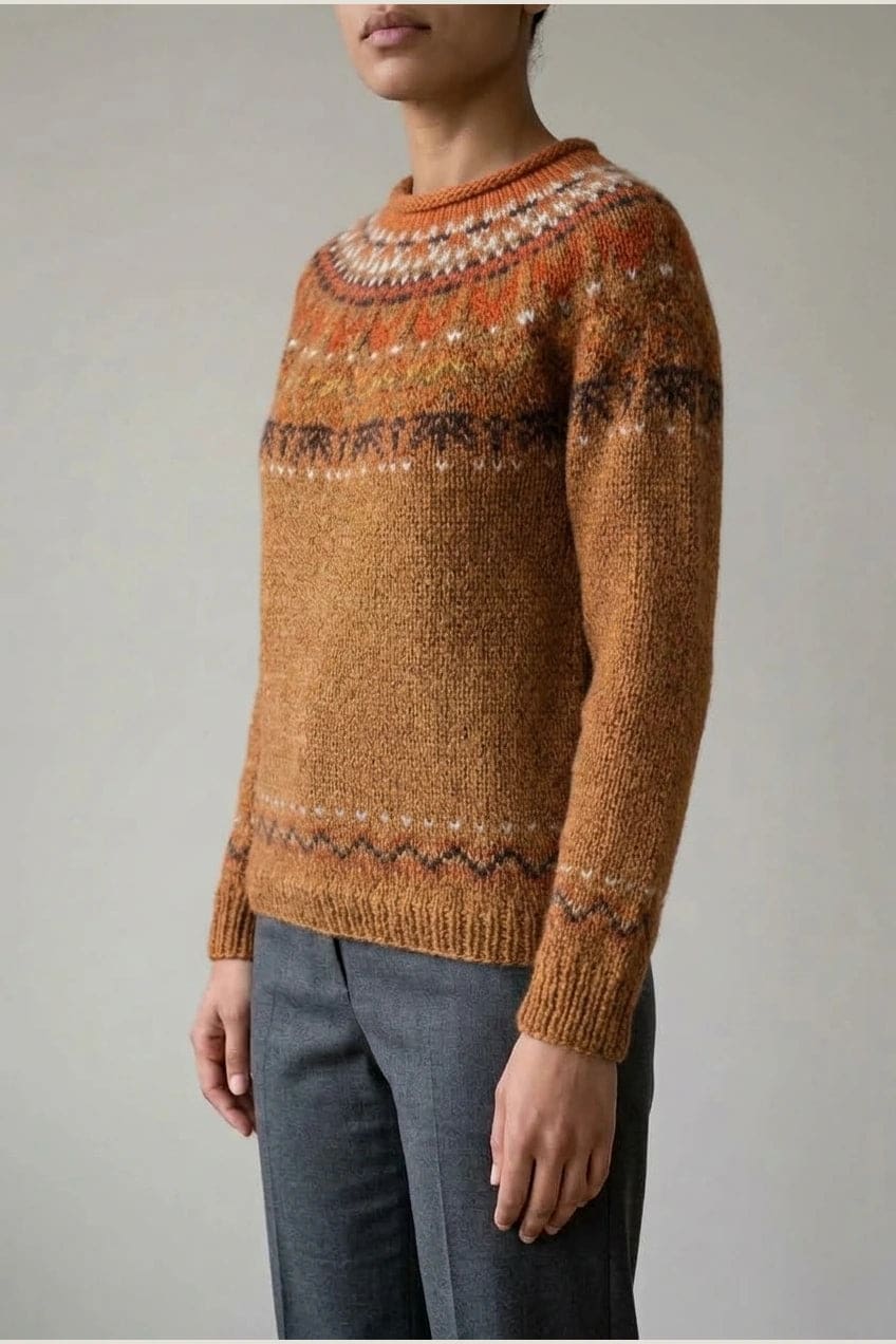 Kvinde i strikket sweater med mønstret rundpasning i zigzag og ribkanter, kombineret med mørke fløjlsbukser og støvler i sne._10