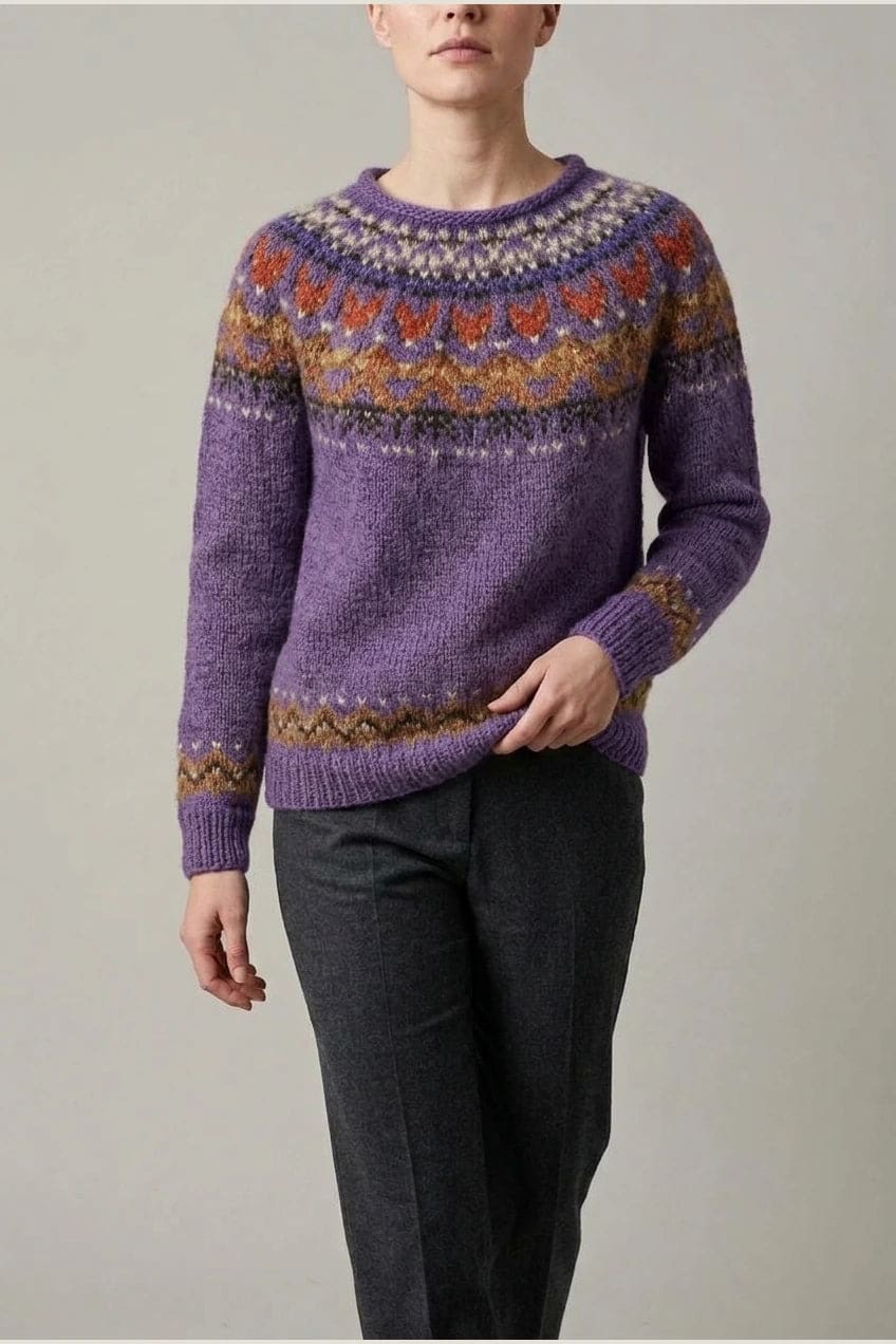 Kvinde i strikket sweater med mønstret rundpasning i zigzag og ribkanter, kombineret med mørke fløjlsbukser og støvler i sne._14