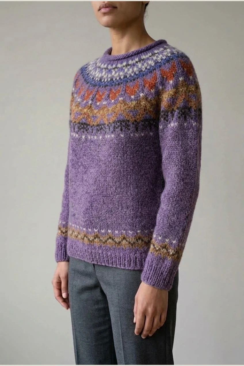 Kvinde i strikket sweater med mønstret rundpasning i zigzag og ribkanter, kombineret med mørke fløjlsbukser og støvler i sne._16
