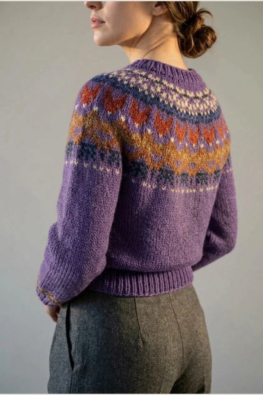 Kvinde i strikket sweater med mønstret rundpasning i zigzag og ribkanter, kombineret med mørke fløjlsbukser og støvler i sne._17
