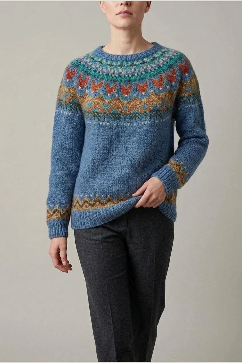 Kvinde i strikket sweater med mønstret rundpasning i zigzag og ribkanter, kombineret med mørke fløjlsbukser og støvler i sne._2