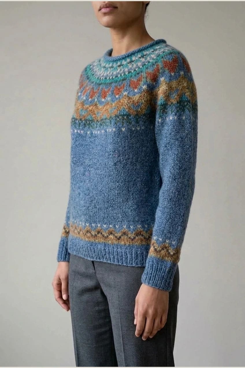 Kvinde i strikket sweater med mønstret rundpasning i zigzag og ribkanter, kombineret med mørke fløjlsbukser og støvler i sne._4