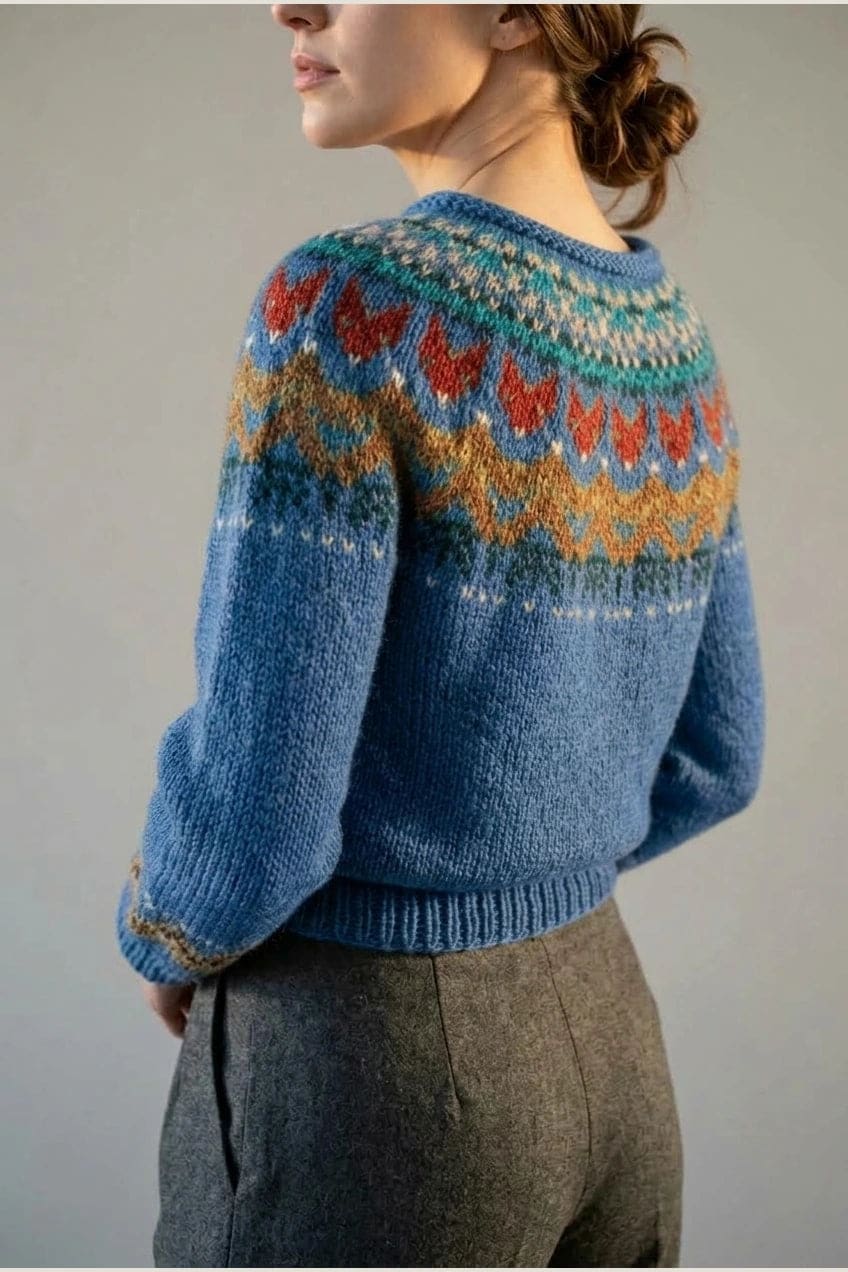 Kvinde i strikket sweater med mønstret rundpasning i zigzag og ribkanter, kombineret med mørke fløjlsbukser og støvler i sne._5