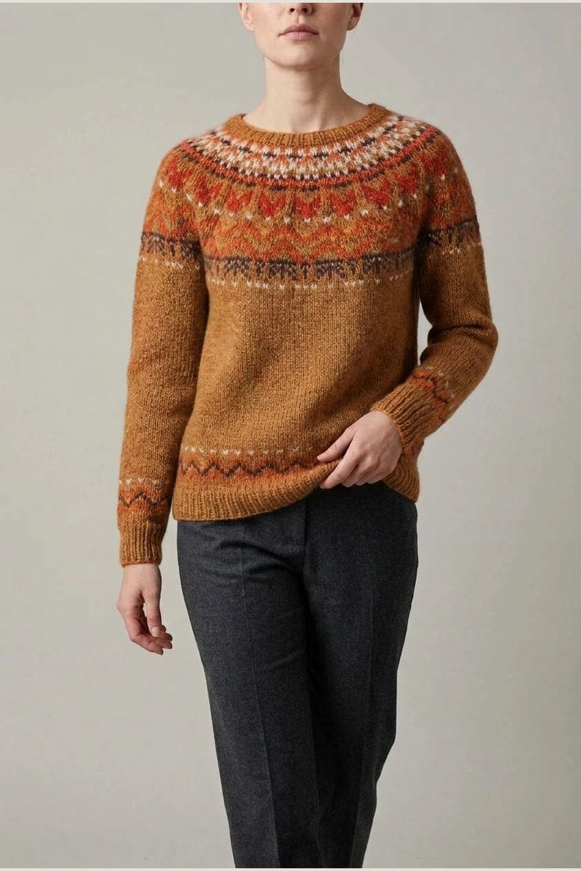 Kvinde i strikket sweater med mønstret rundpasning i zigzag og ribkanter, kombineret med mørke fløjlsbukser og støvler i sne._8