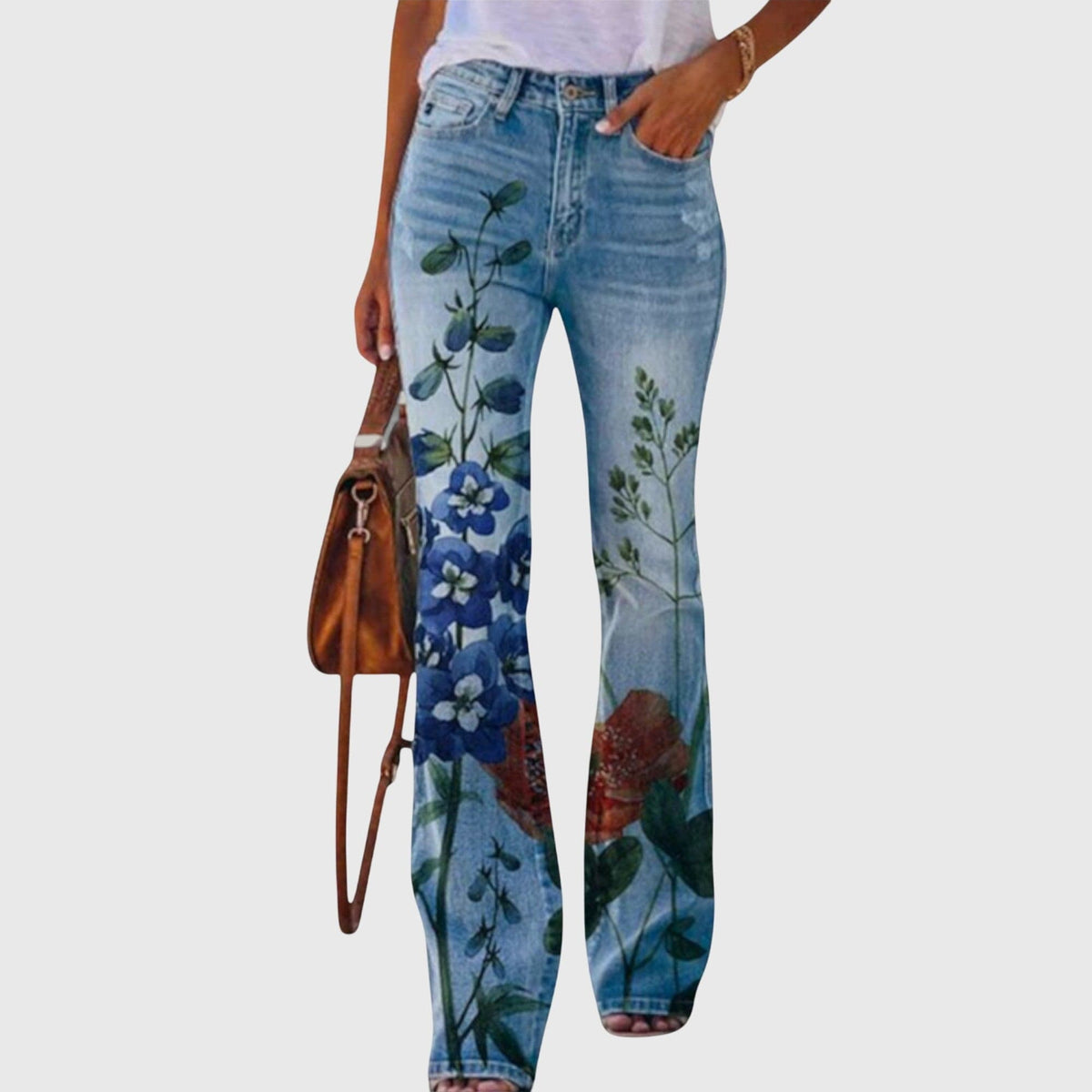 Kvinde iført jeans med vid pasform og farverige blomstermotiver, der går fra taljen og ned langs benene._4