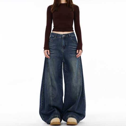 En model bærer mørke jeans med ekstra vide ben og synlige sømdetaljer mod en lys baggrund._0