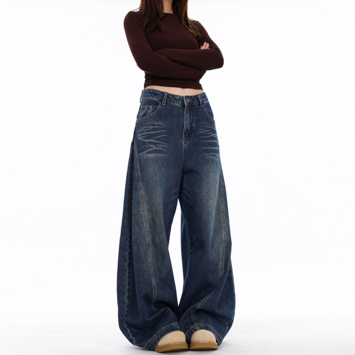 En model bærer mørke jeans med ekstra vide ben og synlige sømdetaljer mod en lys baggrund._1