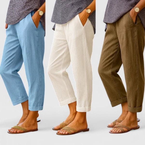 Kvinde bærer beige bukser med afslappet pasform og opslag, stylet med et mørkegrå mønstret skjorte, et guldur og sandaler._5