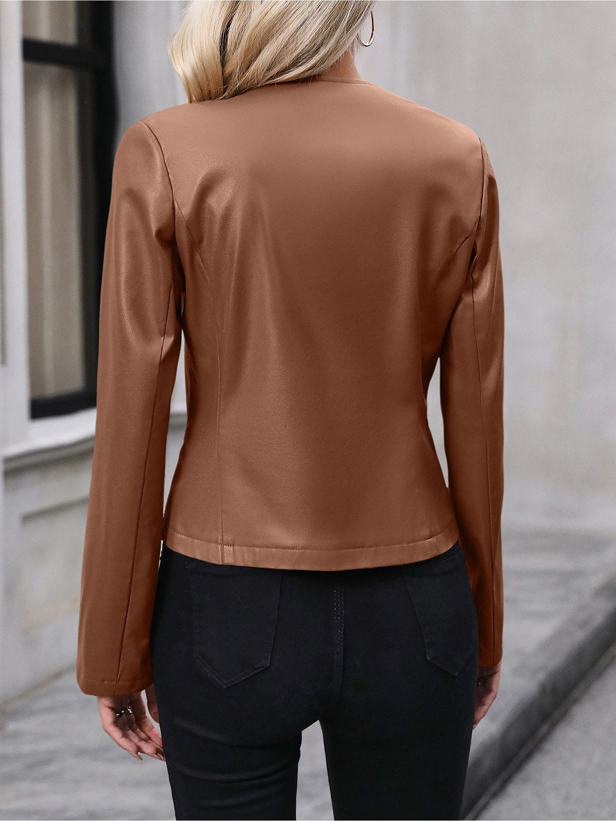 Kvinde iført sort kort jakke med lynlås foran, stylet med sort crop top og sorte bukser i elegant indendørsmiljø._9