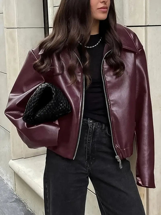 Kvinde iført kort jakke med krave og lynlås i burgundy nuance, stylet med sort top og sorte jeans._0