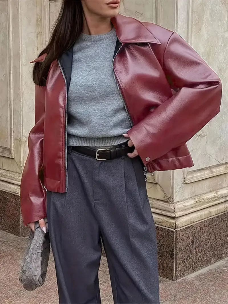 Kvinde iført kort jakke med krave og lynlås i burgundy nuance, stylet med sort top og sorte jeans._10