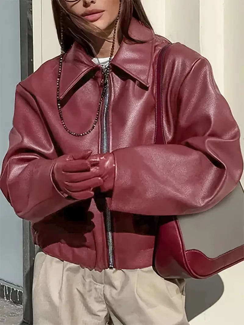 Kvinde iført kort jakke med krave og lynlås i burgundy nuance, stylet med sort top og sorte jeans._11