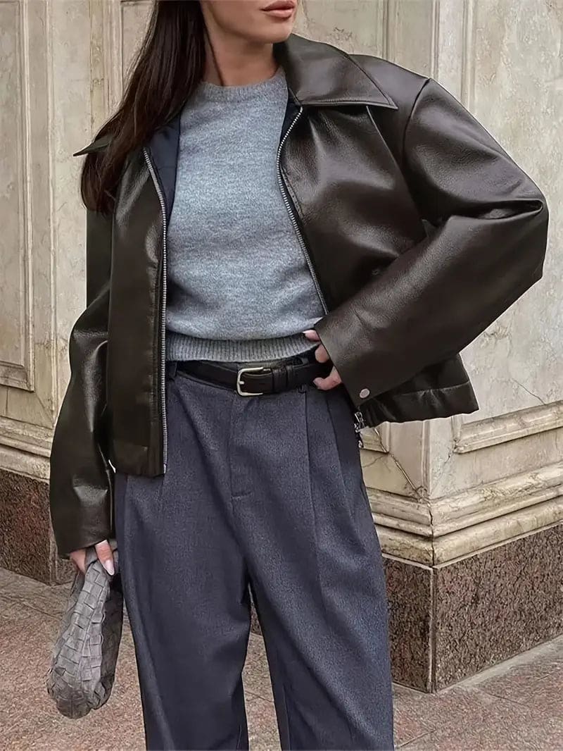 Kvinde iført kort jakke med krave og lynlås i burgundy nuance, stylet med sort top og sorte jeans._15