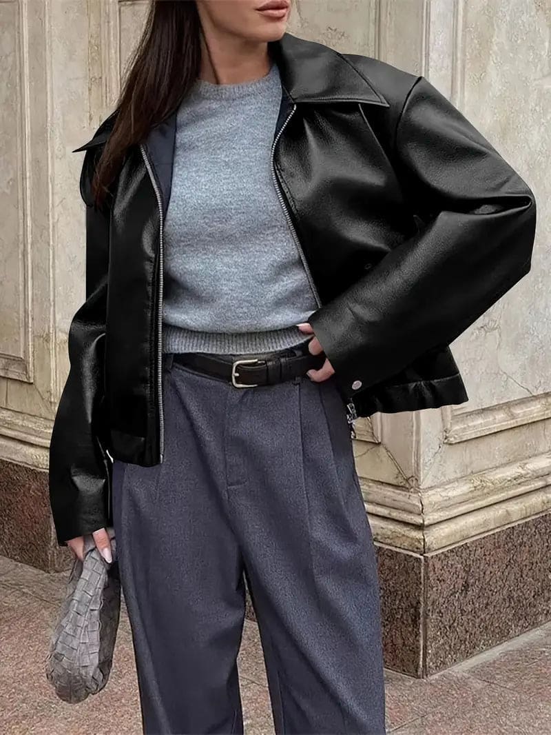 Kvinde iført kort jakke med krave og lynlås i burgundy nuance, stylet med sort top og sorte jeans._5