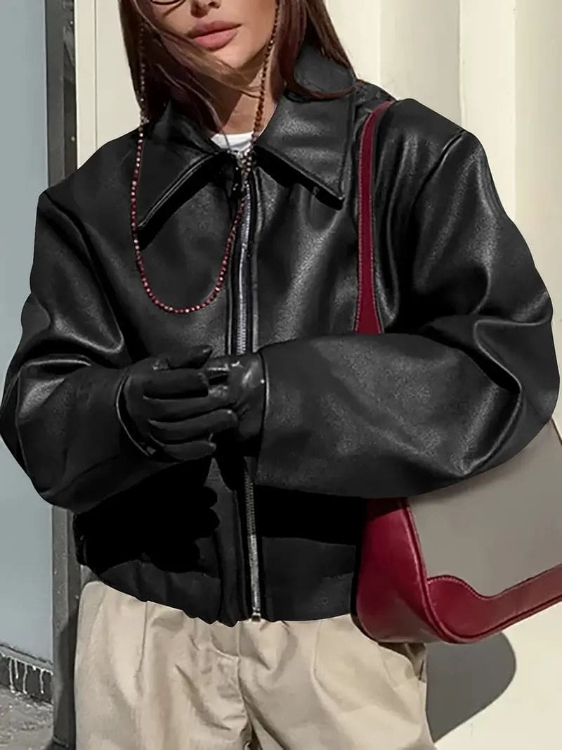 Kvinde iført kort jakke med krave og lynlås i burgundy nuance, stylet med sort top og sorte jeans._6