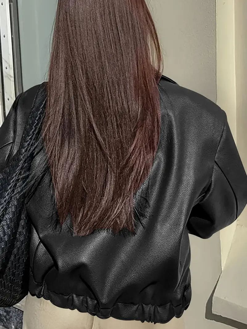 Kvinde iført kort jakke med krave og lynlås i burgundy nuance, stylet med sort top og sorte jeans._7