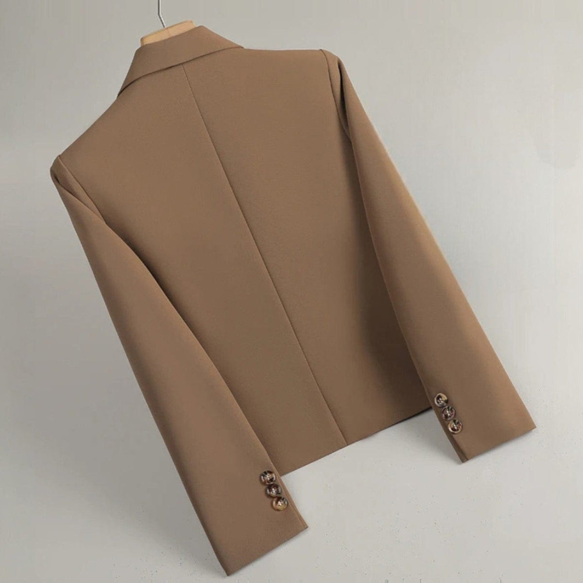 En figursyet blazer med klassiske revers, to knapper, klaplommer og knapdetaljer ved manchetterne på en bøjle._2