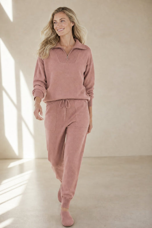 Model iført et loungewear-sæt bestående af en sweatshirt med halv lynlås og matchende joggingbukser i rosenfarvet nuance._0
