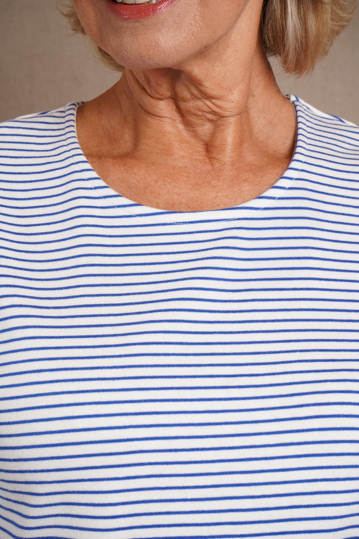 Kvinde i stribet bluse med rund hals og trekvartlange ærmer, båret til jeans._7