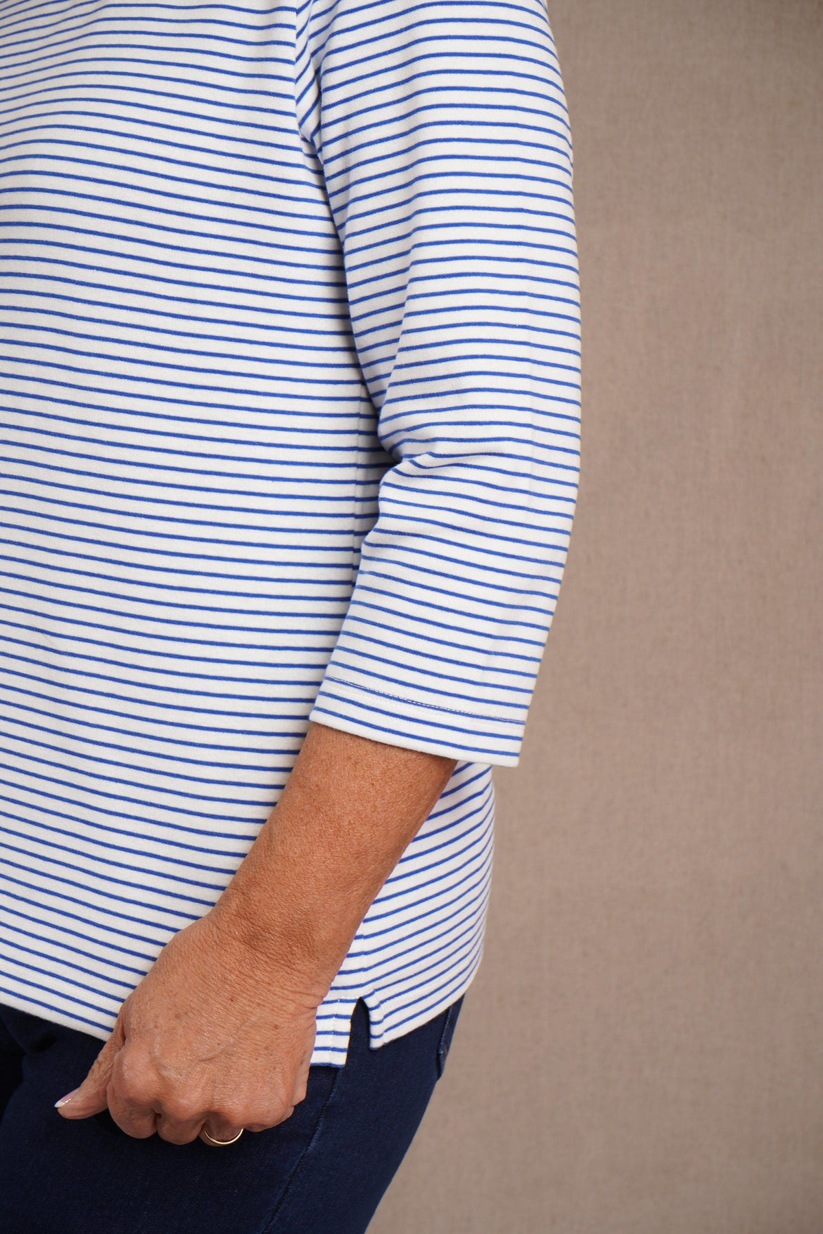 Kvinde i stribet bluse med rund hals og trekvartlange ærmer, båret til jeans._8