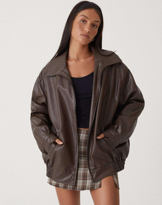 Model iført en oversize jakke med krave, lynlås og drop-skuldre, styling med sort top og ternet nederdel._0