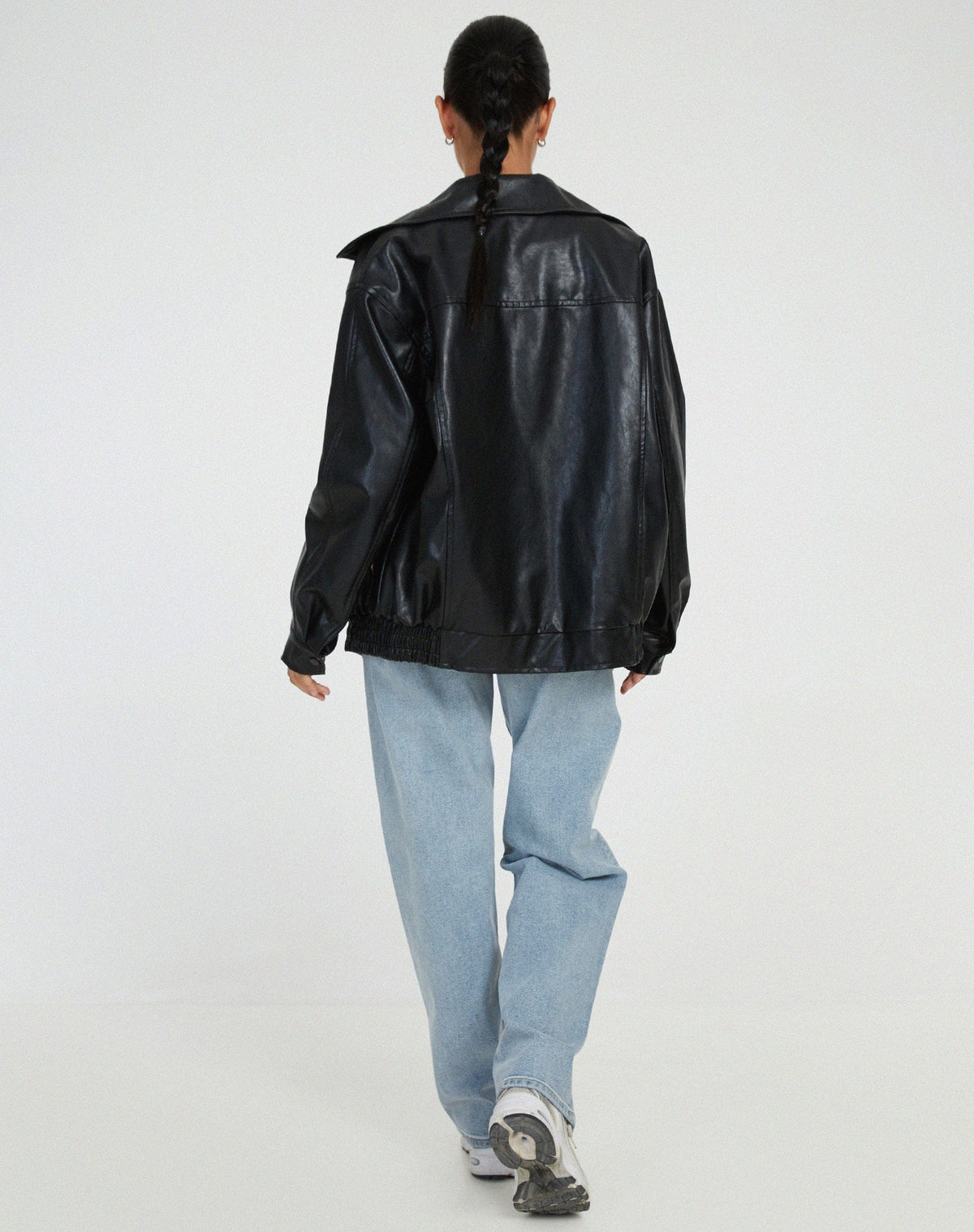 Model iført en oversize jakke med krave, lynlås og drop-skuldre, styling med sort top og ternet nederdel._4