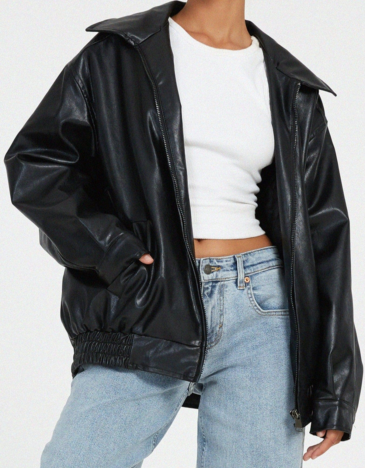 Model iført en oversize jakke med krave, lynlås og drop-skuldre, styling med sort top og ternet nederdel._5
