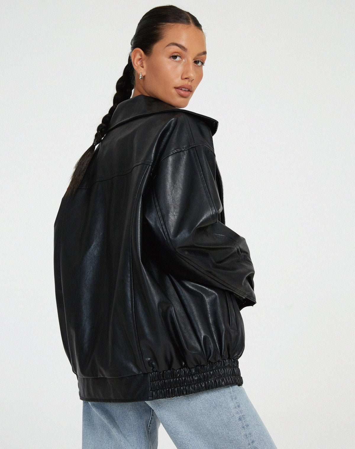 Model iført en oversize jakke med krave, lynlås og drop-skuldre, styling med sort top og ternet nederdel._6
