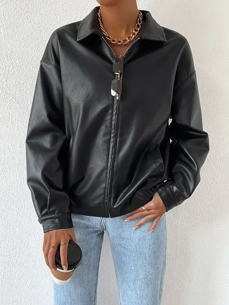 Kvinde iført en oversize jakke med lynlås og krave, stylet med hvid crop top og lyse jeans._1