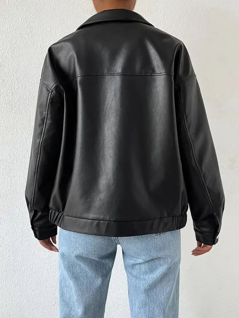 Kvinde iført en oversize jakke med lynlås og krave, stylet med hvid crop top og lyse jeans._2