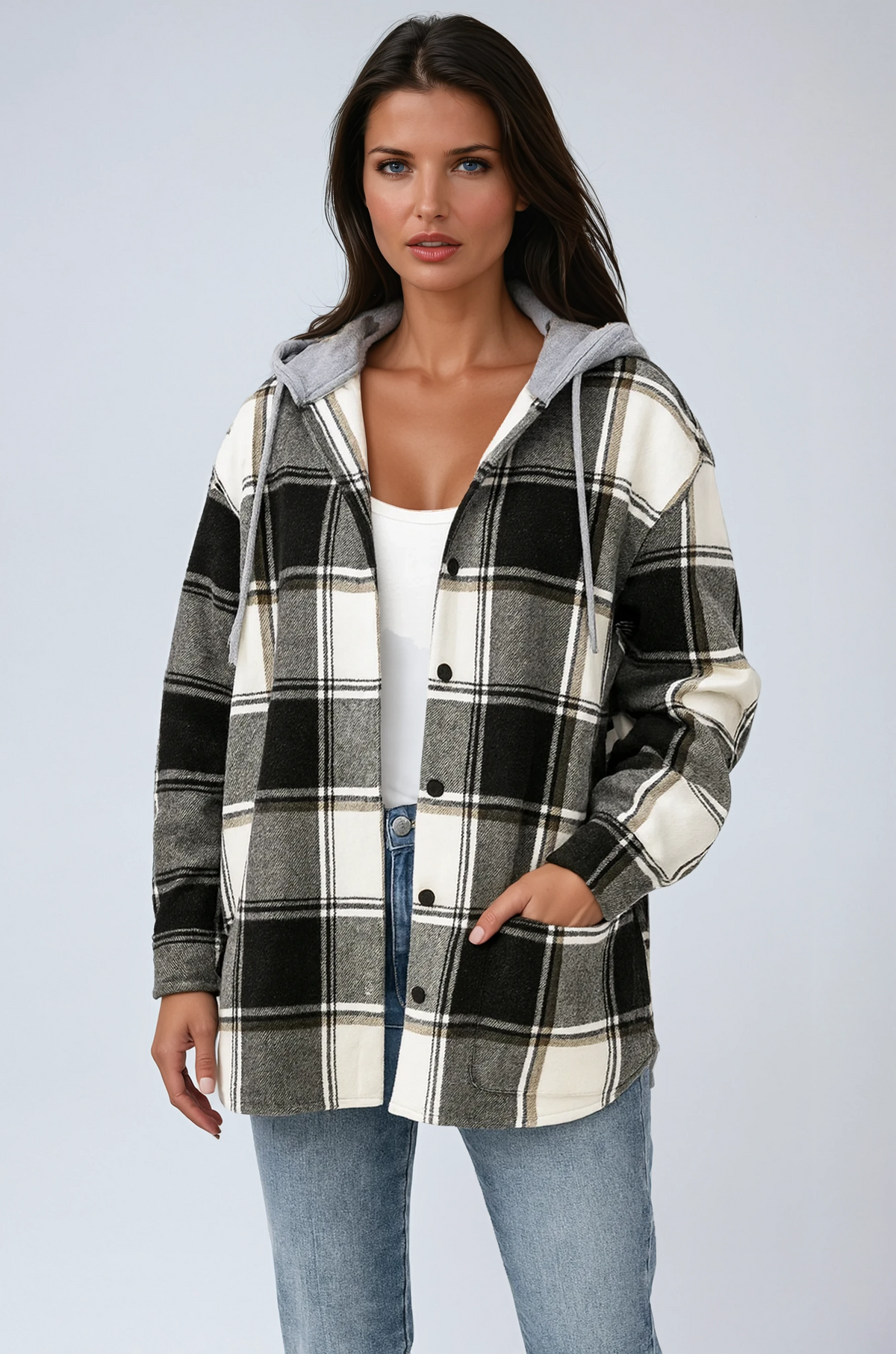 Kvinde i ternet skjortejakke med grå hætte, trykknapper og lommer, stylet med jeans og hvid top._0