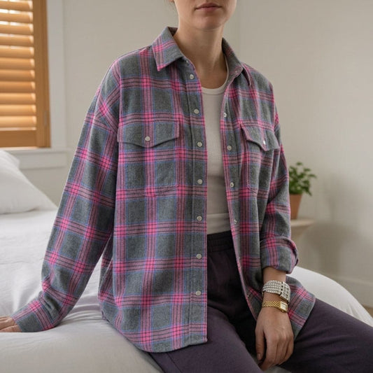 Kvinde der bærer en oversized skjorte i ternmønster med lyserøde og grå farver, fotograferet indendørs_0