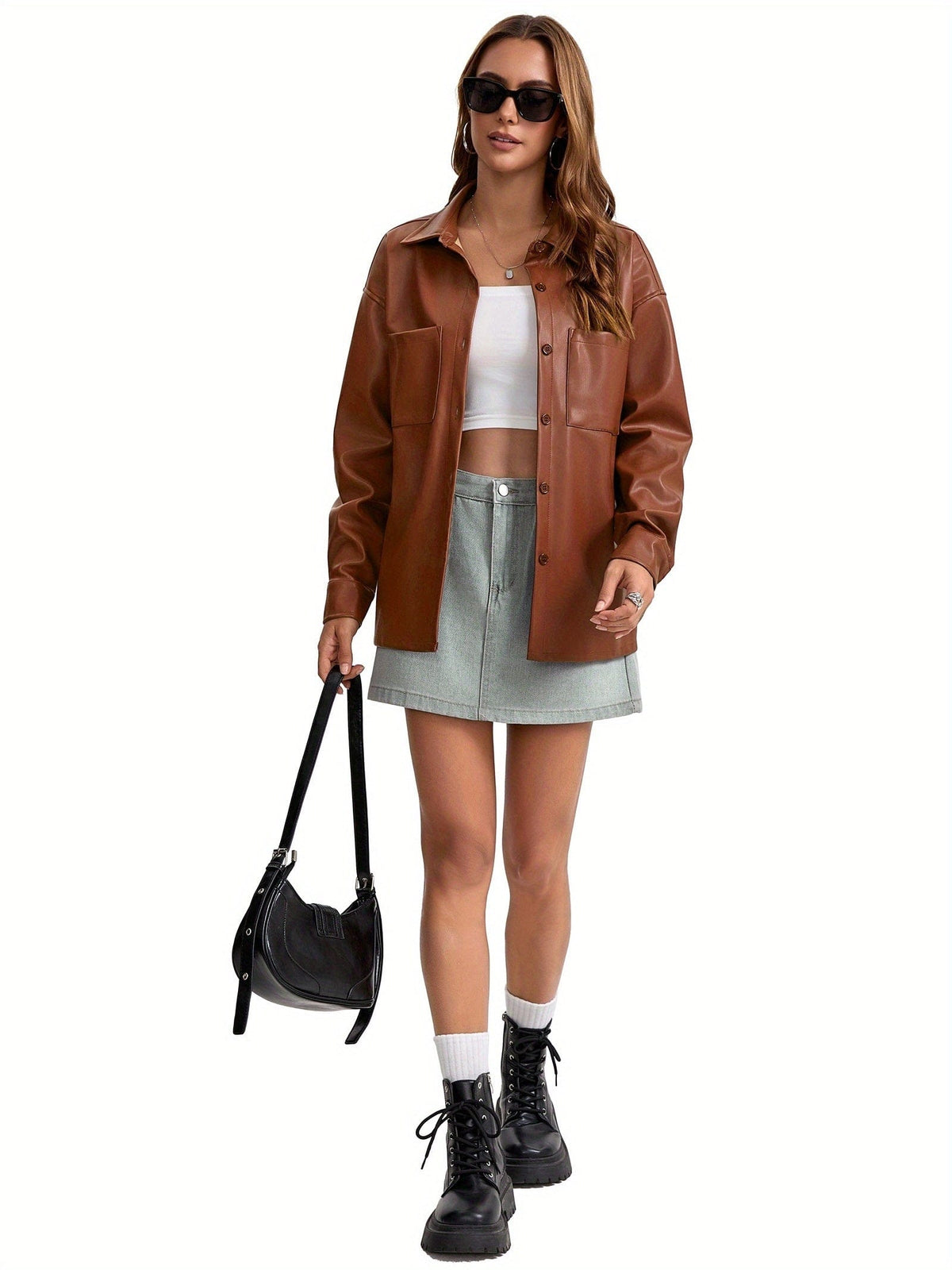 Kvinde iført oversized skjortejakke med krave, knaplukning foran og brystlommer, stylet med brune shorts._2
