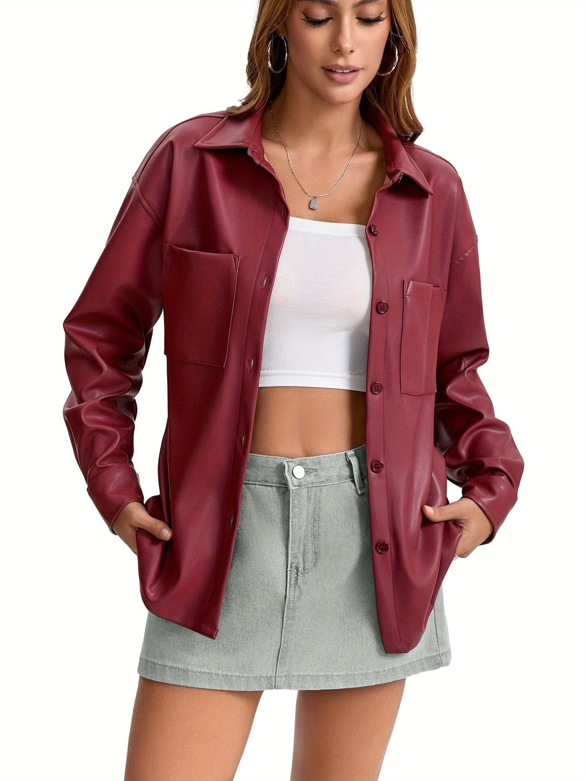 Kvinde iført oversized skjortejakke med krave, knaplukning foran og brystlommer, stylet med brune shorts._4