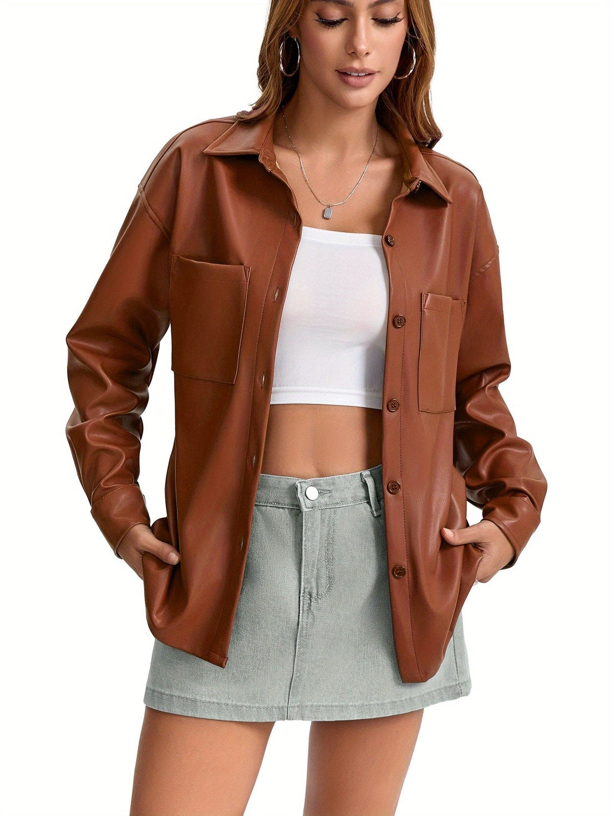 Kvinde iført oversized skjortejakke med krave, knaplukning foran og brystlommer, stylet med brune shorts._5