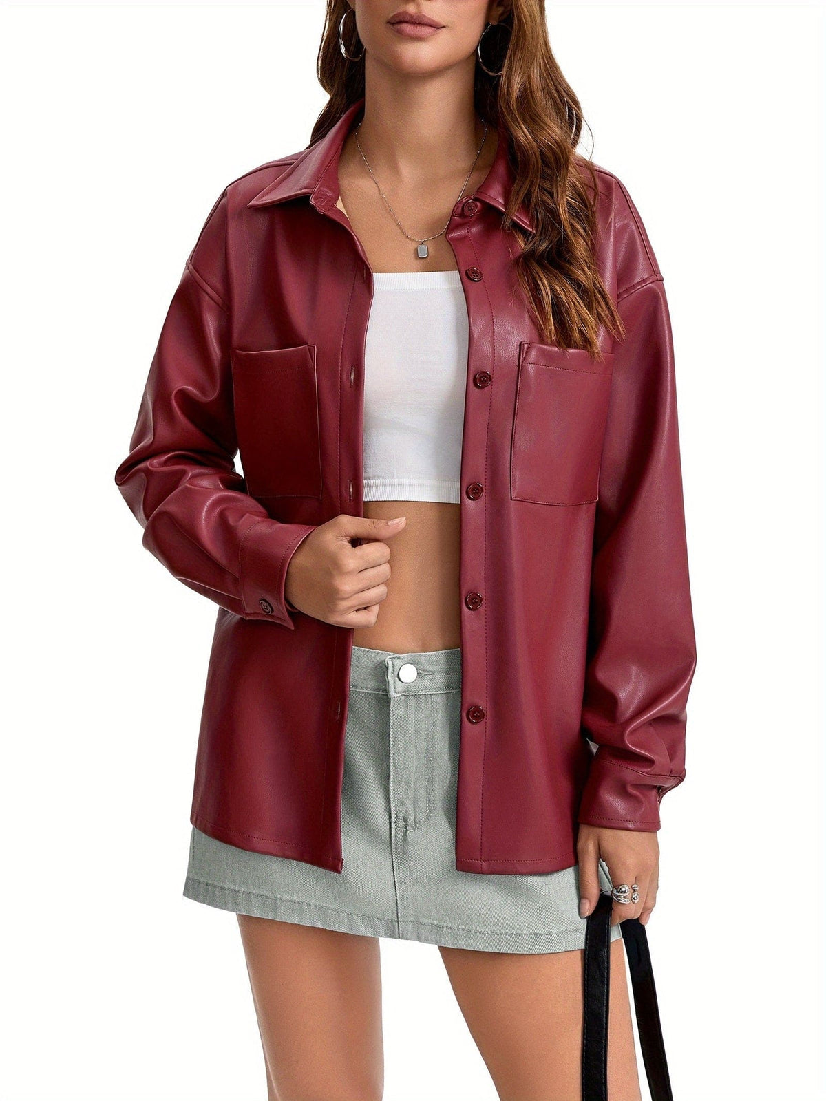 Kvinde iført oversized skjortejakke med krave, knaplukning foran og brystlommer, stylet med brune shorts._7