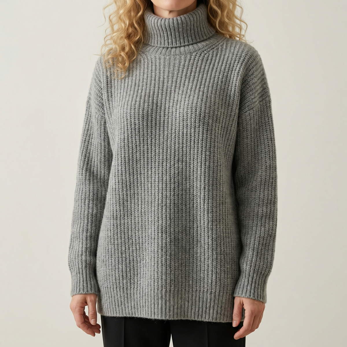 Kvinde iført en grå oversized strik sweater med høj hals og afslappet pasform_0