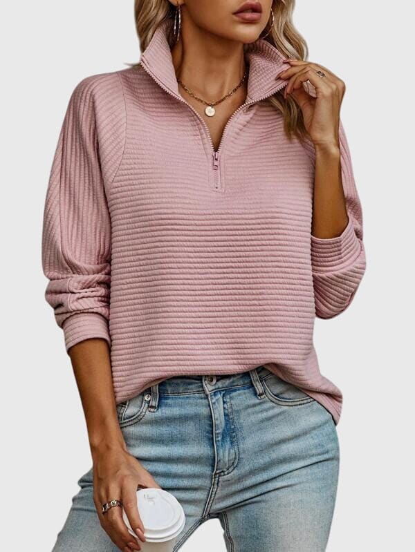 Model iført lys rosa ribstrikket sweater med halvlynlås i halsen og afslappet pasform, kombineret med lyse jeans._2