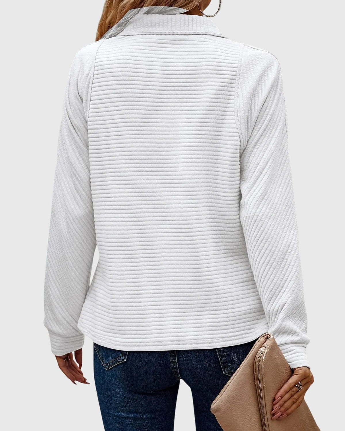 Model iført lys rosa ribstrikket sweater med halvlynlås i halsen og afslappet pasform, kombineret med lyse jeans._9