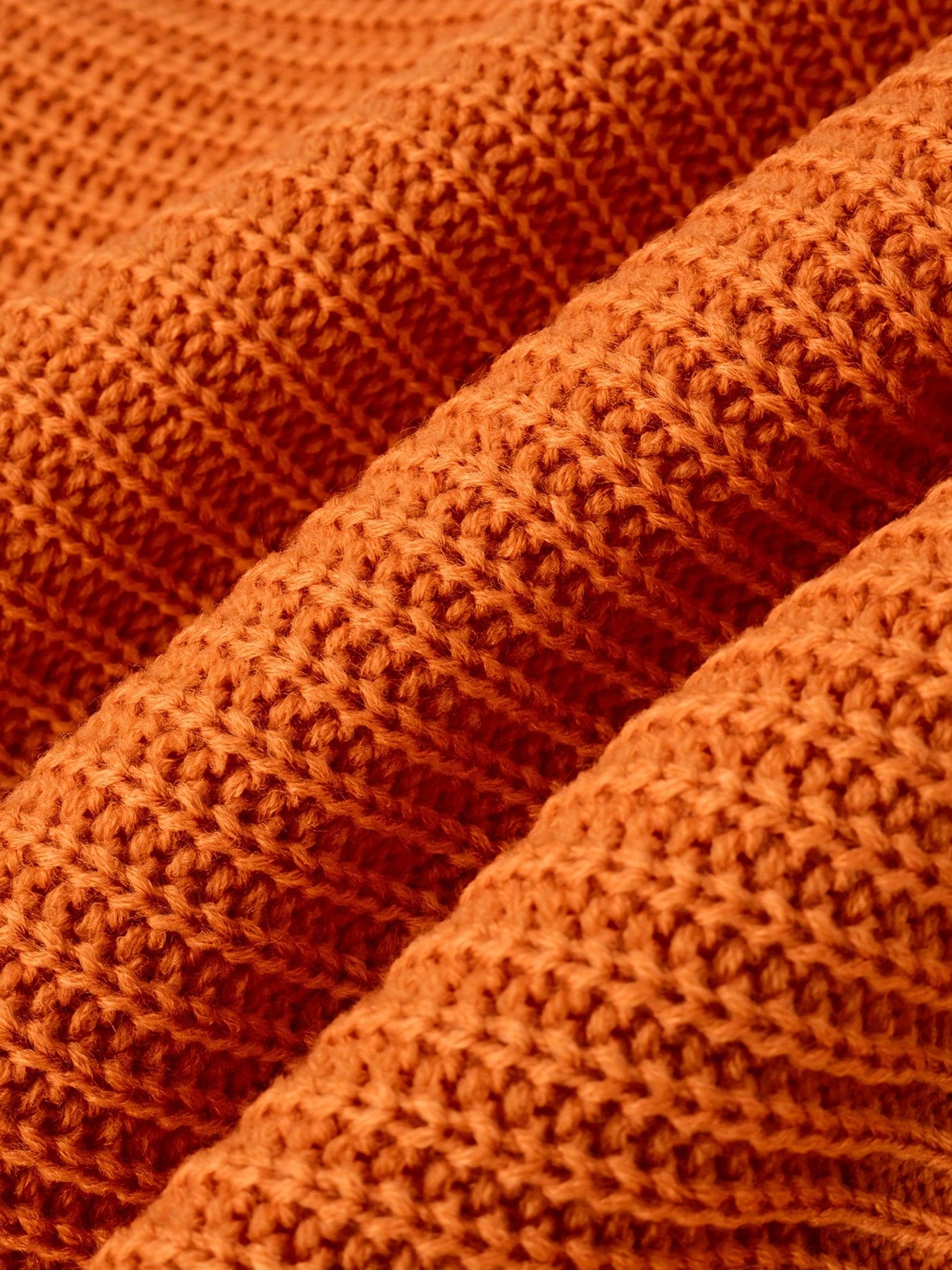En ribstrikket sweater med rullekrave og afslappet pasform hænger på en bøjle mod lys baggrund._3