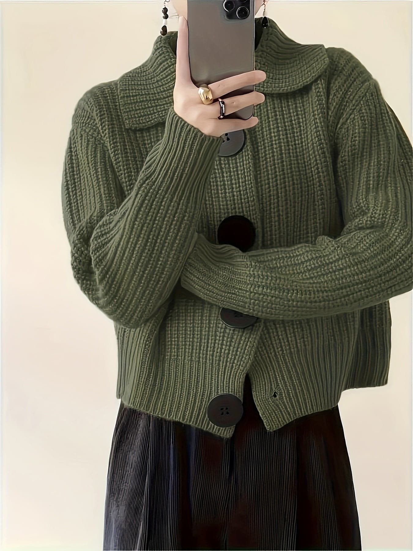 En ribstrikket sweater med rullekrave og afslappet pasform hænger på en bøjle mod lys baggrund._5