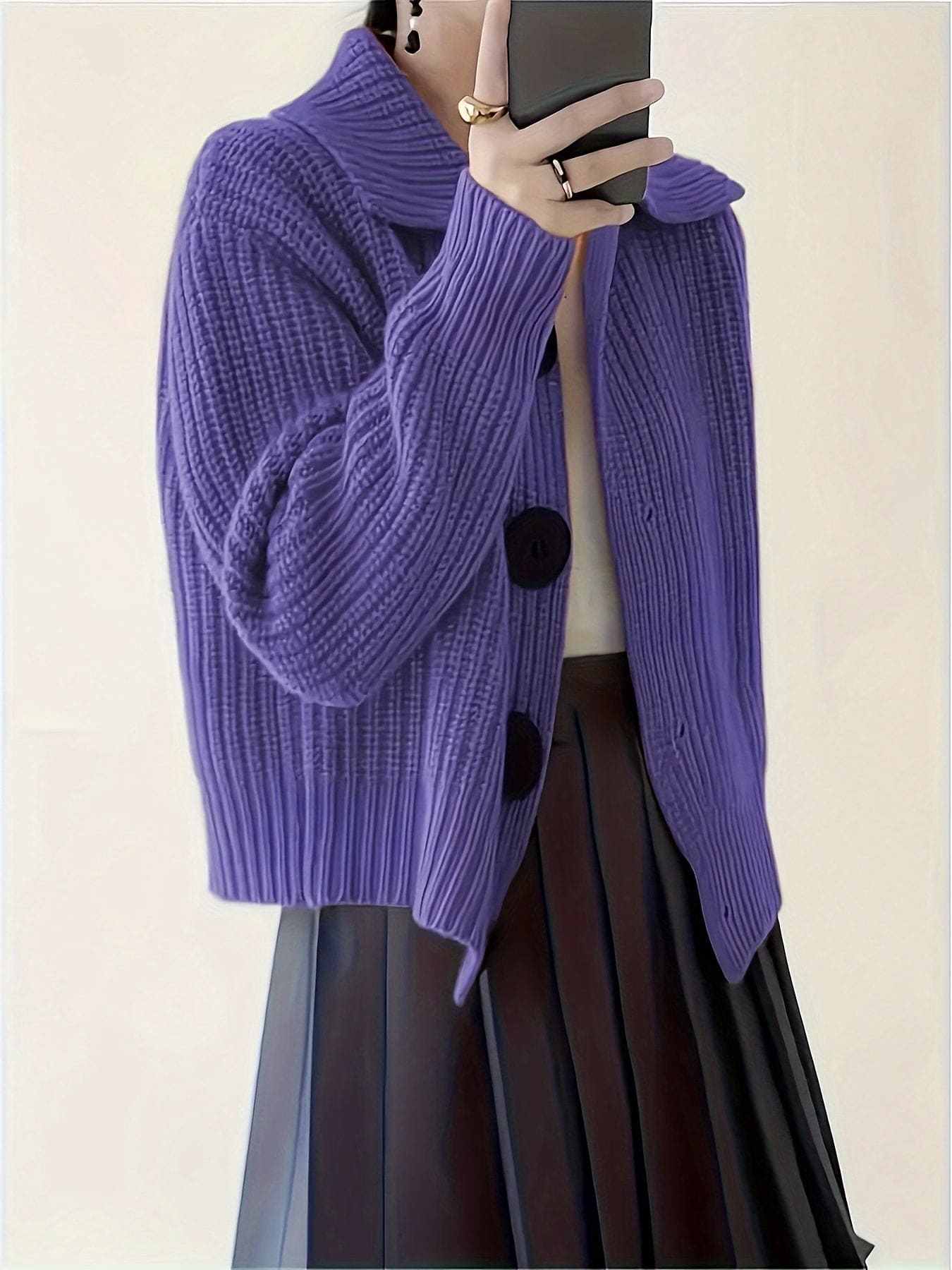 En ribstrikket sweater med rullekrave og afslappet pasform hænger på en bøjle mod lys baggrund._6