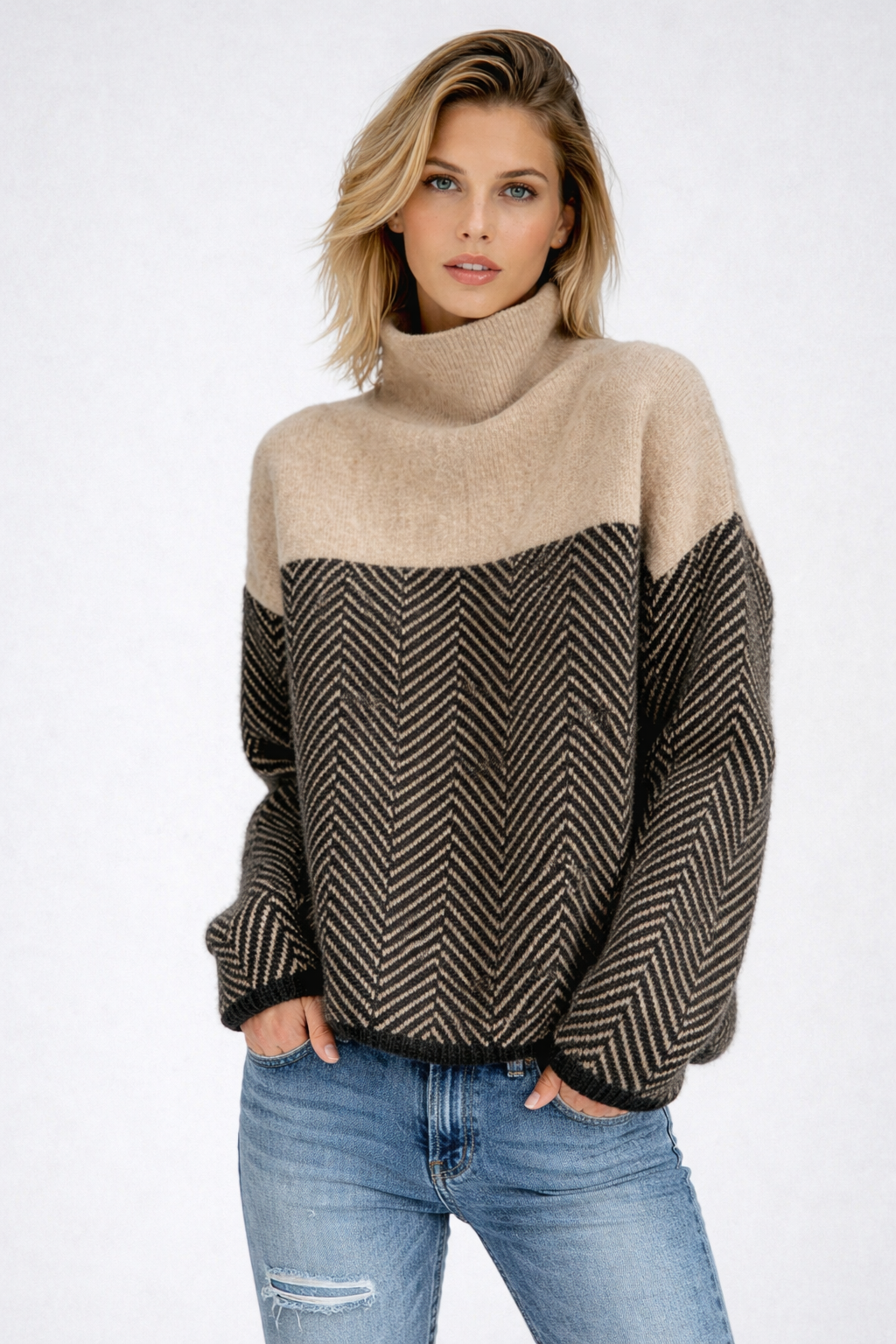 Kvinde iført en beige og sort sweater med rullekrave og chevron-mønster, stylet med lyse jeans._0