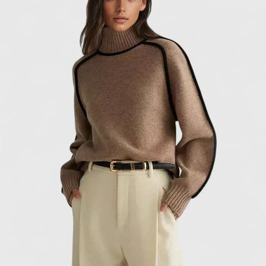 Kvinde iført en brun rullekrave sweater med kontrasterende sorte kantsømme, stylet med lyse bukser og et bælte._0