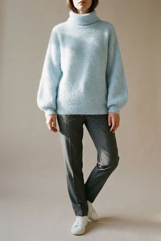 Model i lys, luftig rullekravesweater med ballonærmer, ribbede manchetter og kant, stylet med grå bukser og hvide sneakers._0