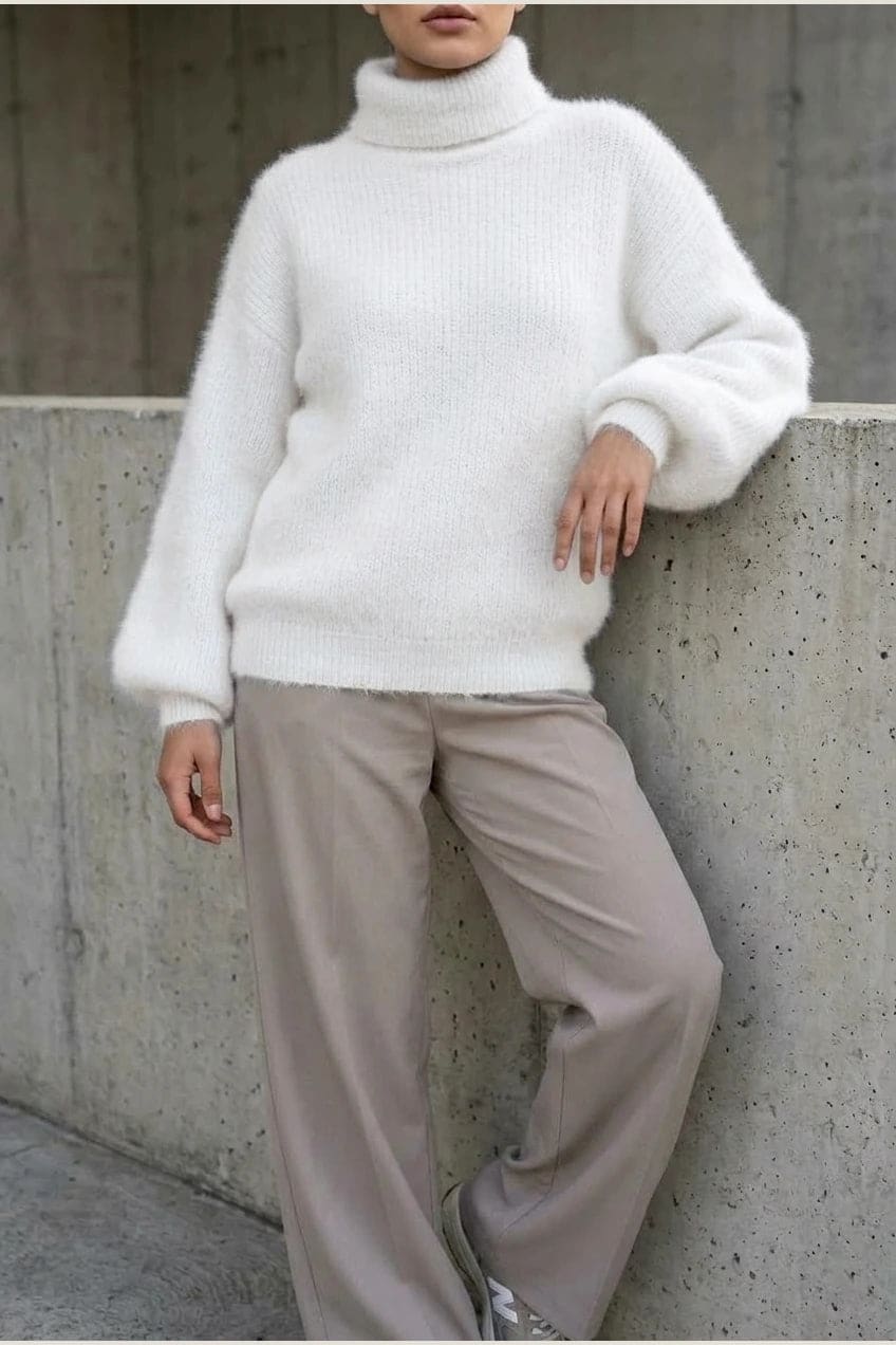 Model i lys, luftig rullekravesweater med ballonærmer, ribbede manchetter og kant, stylet med grå bukser og hvide sneakers._2