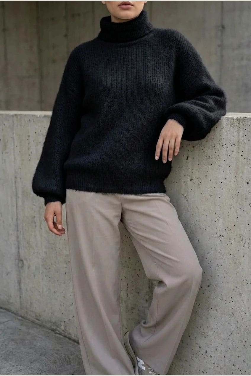 Model i lys, luftig rullekravesweater med ballonærmer, ribbede manchetter og kant, stylet med grå bukser og hvide sneakers._26