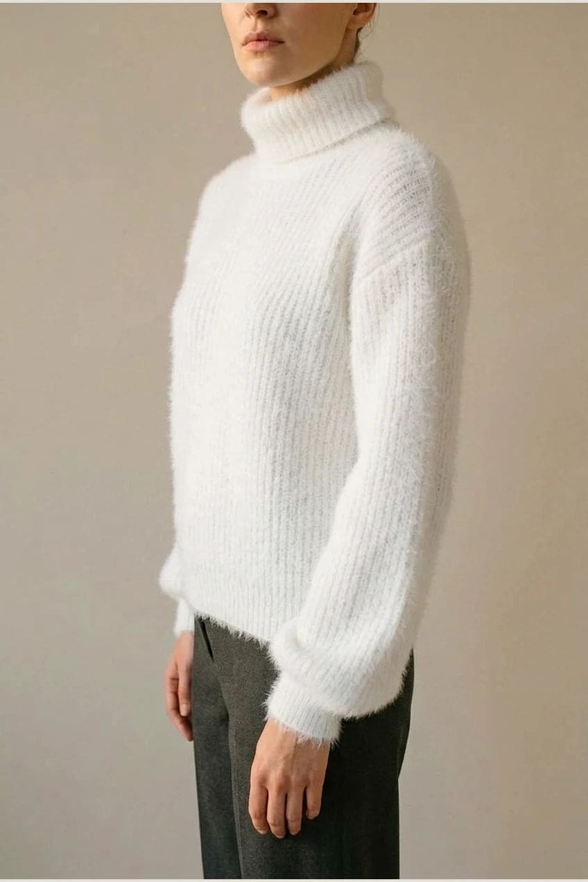 Model i lys, luftig rullekravesweater med ballonærmer, ribbede manchetter og kant, stylet med grå bukser og hvide sneakers._3